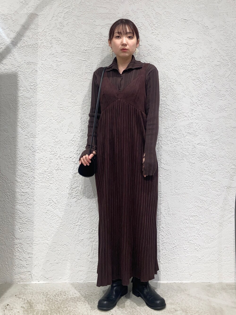 レッド系のワンピース、ブラウン系のニット/セーター、ブラック系のショルダーバッグを着用したレディースの秋コーディネートの1枚目の写真