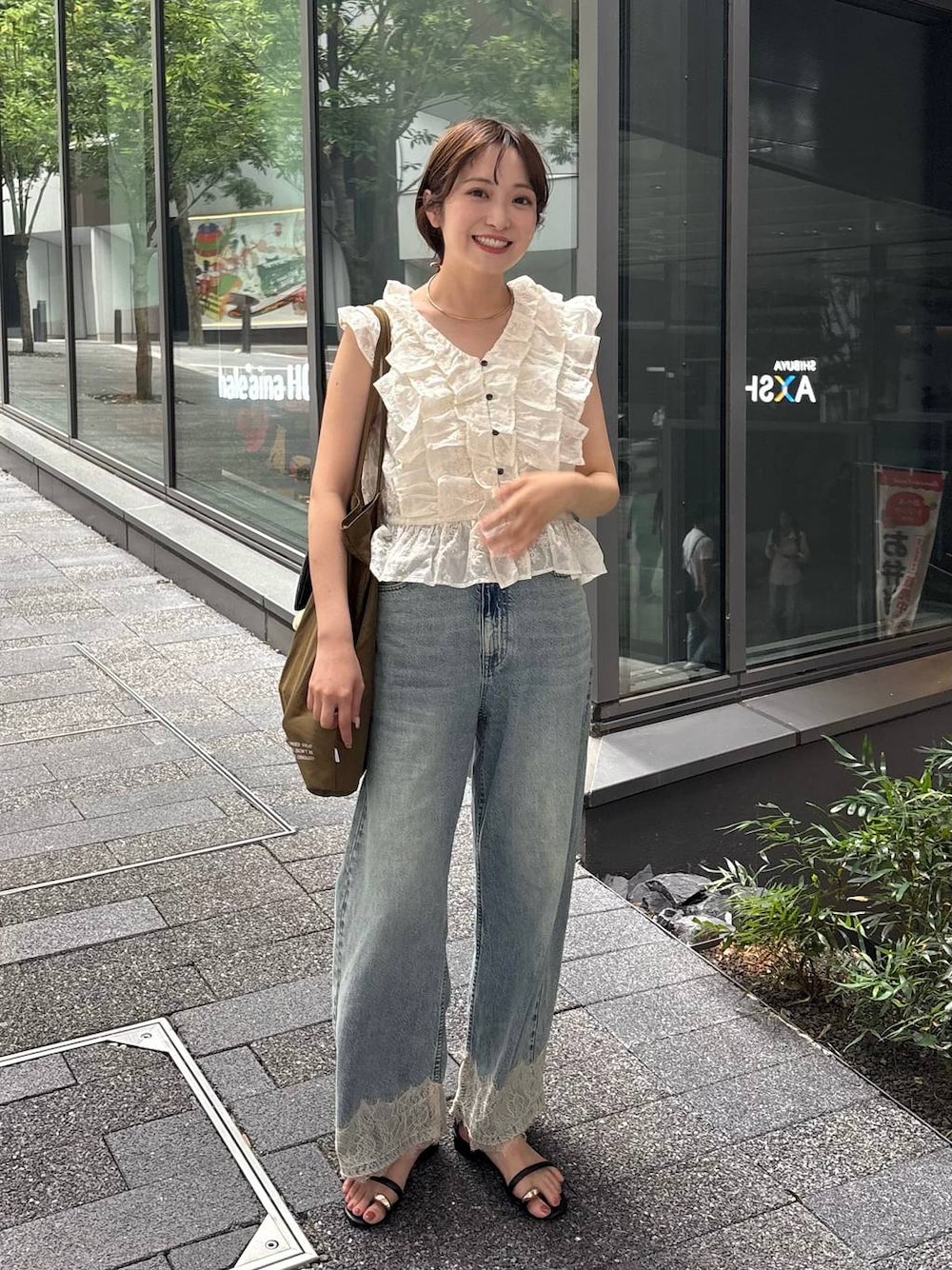 ブラック系のサンダル、ブルー系のデニムパンツ、ホワイト系のTシャツ/カットソーを着用したレディースの夏コーディネートの1枚目の写真