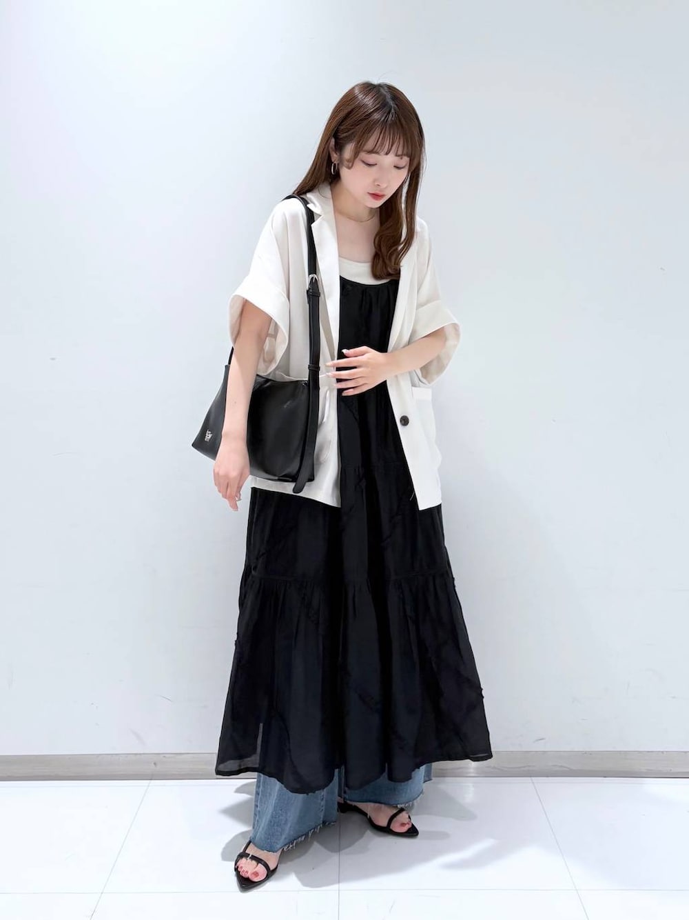 ホワイト系のTシャツ/カットソー、ブラック系のサンダル、ブルー系のデニムパンツを着用したレディースの春コーディネートの1枚目の写真