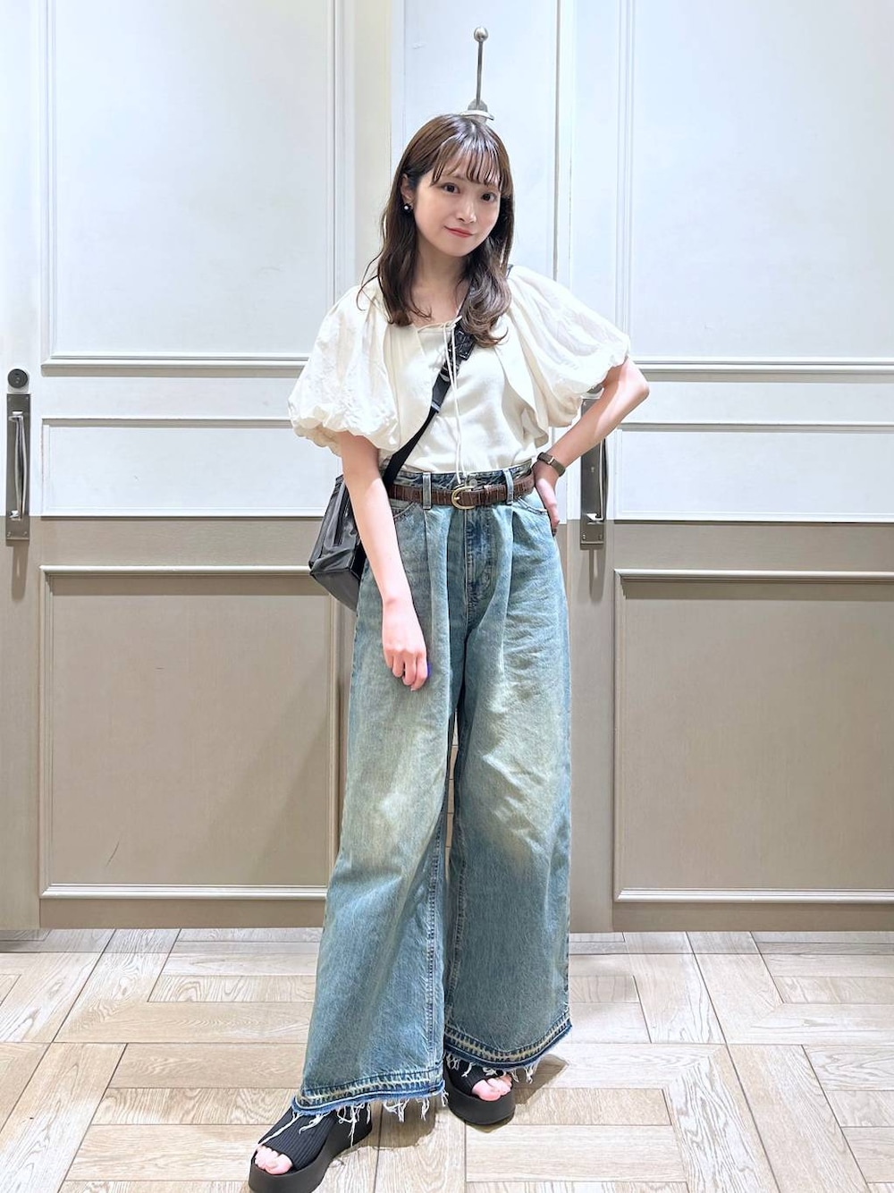 ホワイト系のTシャツ/カットソー、ブラック系のサンダル、ブルー系のデニムパンツを着用したレディースの春コーディネートの1枚目の写真