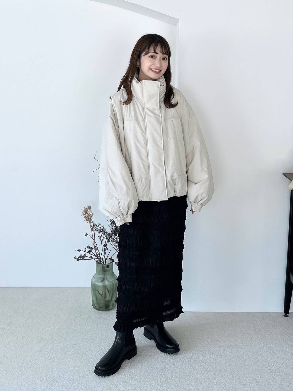 ブラック系のブーツ、ブラック系のスカート、ゴールド系のピアス(両耳用)を着用したレディースの夏コーディネートの1枚目の写真