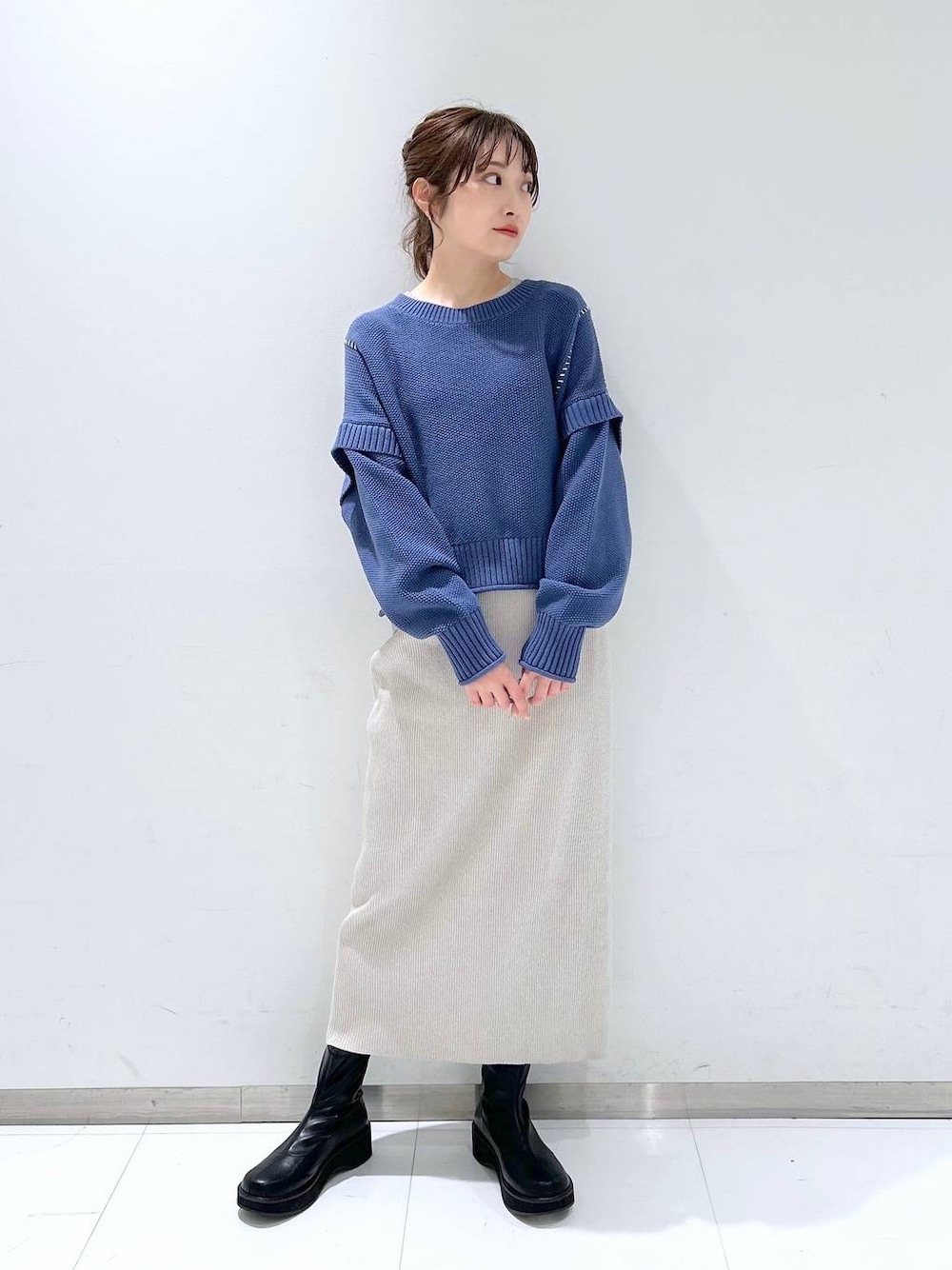 ブルー系のTシャツ/カットソー、ブラック系のブーツ、グレー系のスカートを着用したレディースの冬コーディネートの1枚目の写真