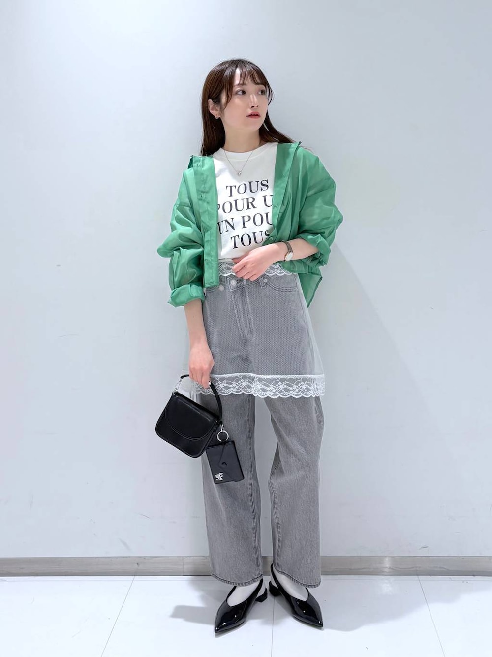 グリーン系のシャツ/ブラウス、グレー系のデニムパンツ、ブラック系のショルダーバッグを着用したレディースの春コーディネートの1枚目の写真