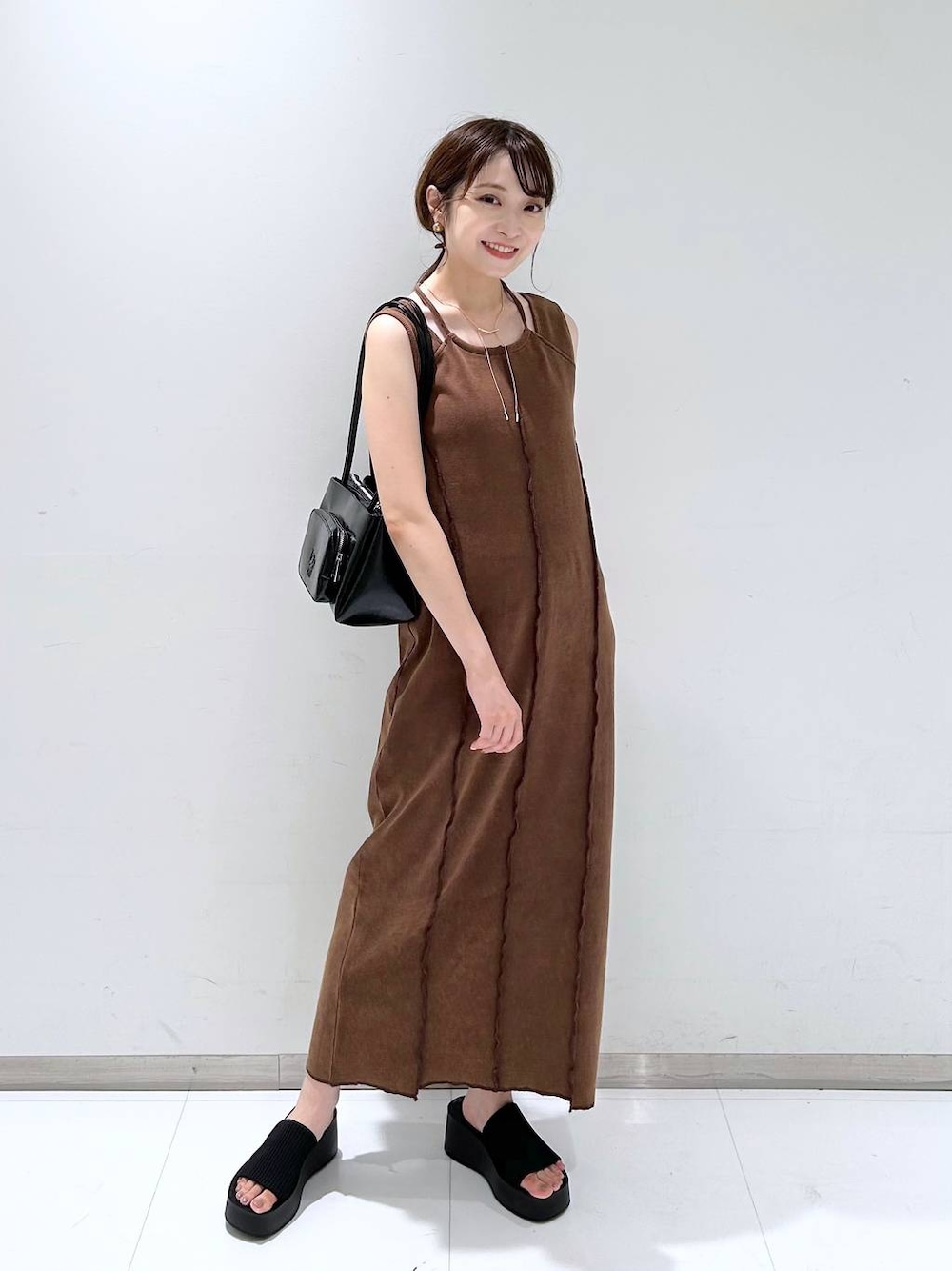 ブラック系のサンダル、ブラウン系のワンピース、ブラック系のショルダーバッグを着用したレディースの夏コーディネートの1枚目の写真