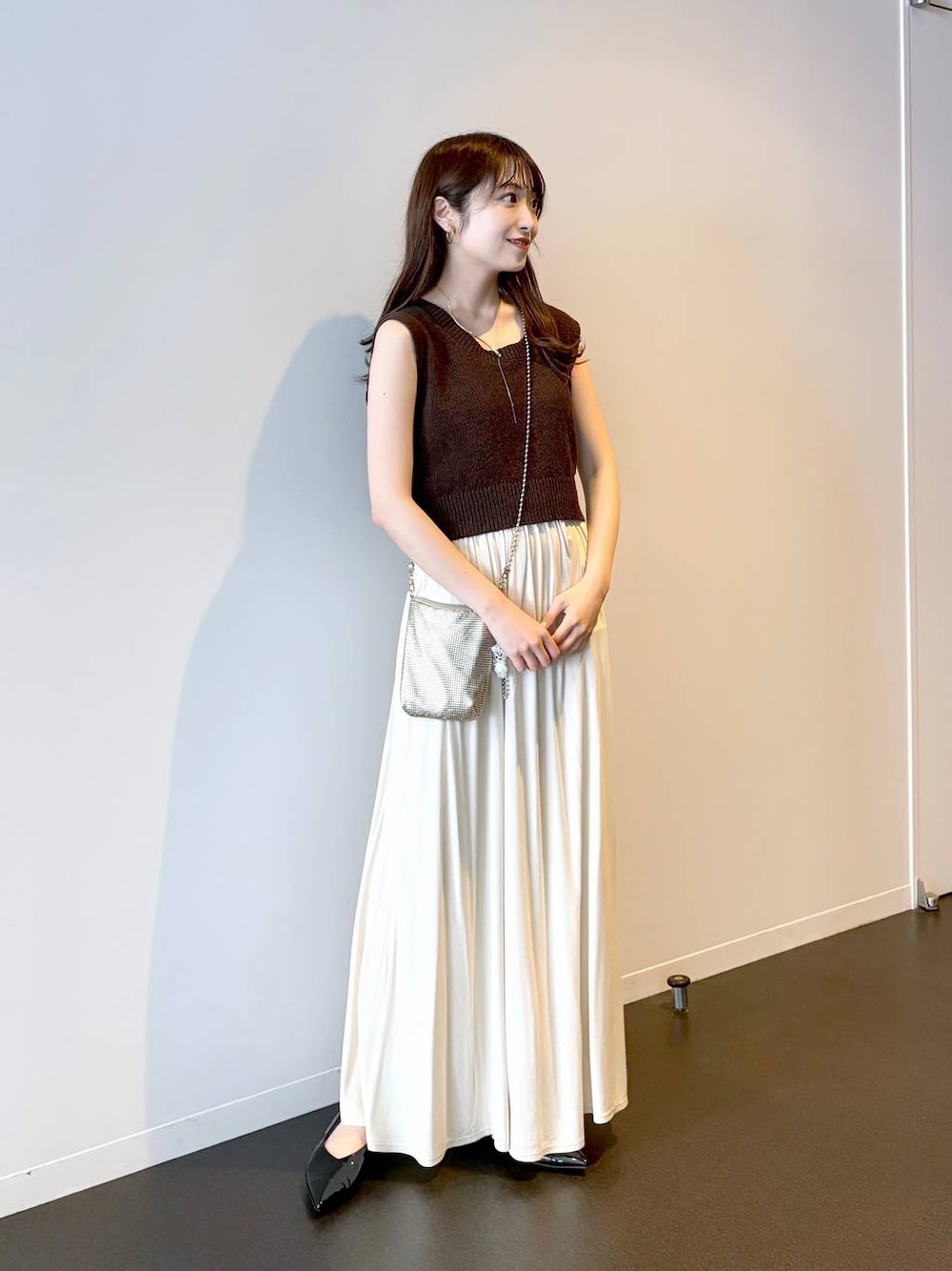 ゴールド系のショルダーバッグ、ブラック系のパンプス、ブラウン系のニット/セーターを着用したレディースの夏コーディネートの1枚目の写真