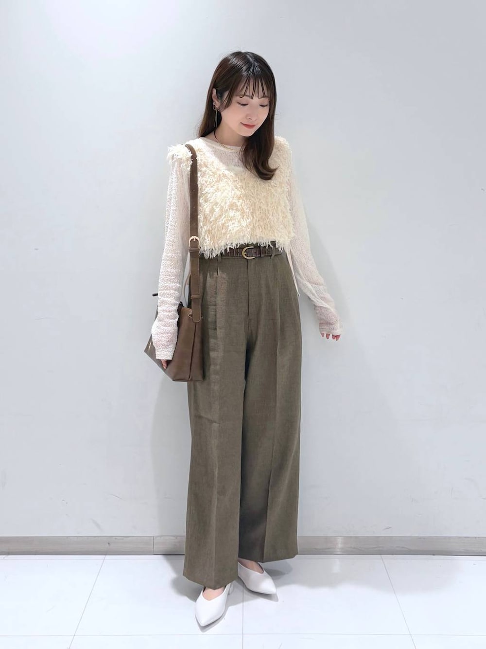 ブラウン系のスラックス、ホワイト系のパンプス、ホワイト系のTシャツ/カットソーを着用したレディースの春コーディネートの1枚目の写真