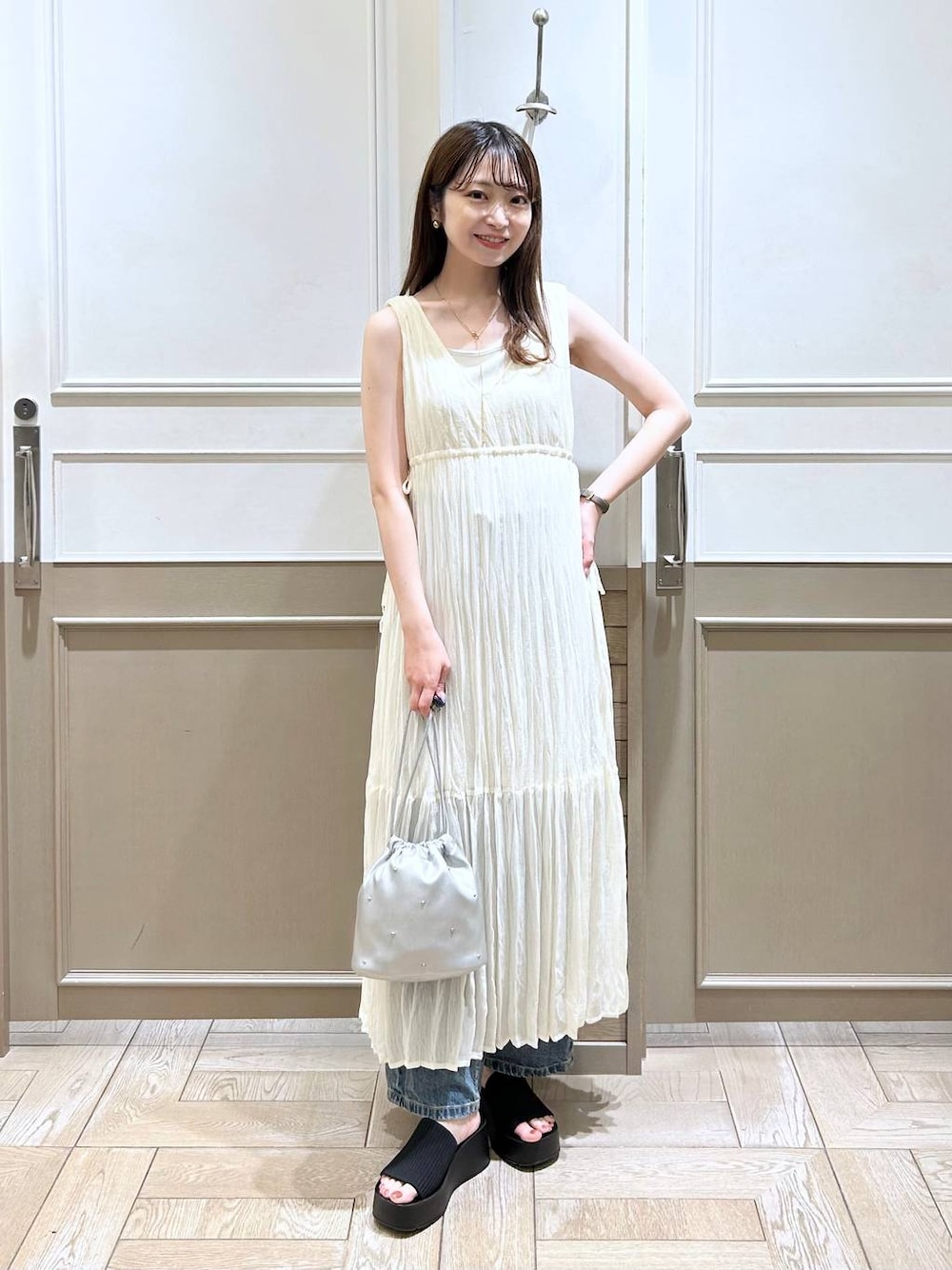 ホワイト系のTシャツ/カットソー、ブラック系のサンダル、ブルー系のデニムパンツを着用したレディースの夏コーディネートの1枚目の写真