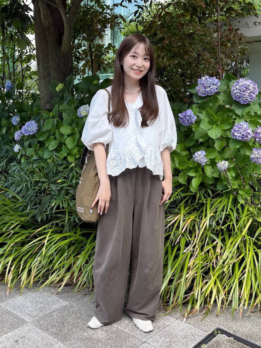ホワイト系のパンプス、ホワイト系のシャツ/ブラウス、ゴールド系のチョーカーを着用したレディースの夏コーディネートの1枚目の写真