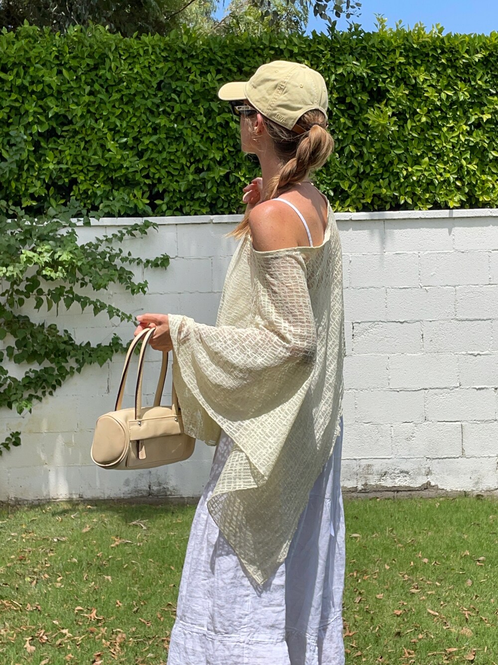 ブラック系のサングラス、イエロー系のキャップを着用したレディースの秋コーディネートの1枚目の写真