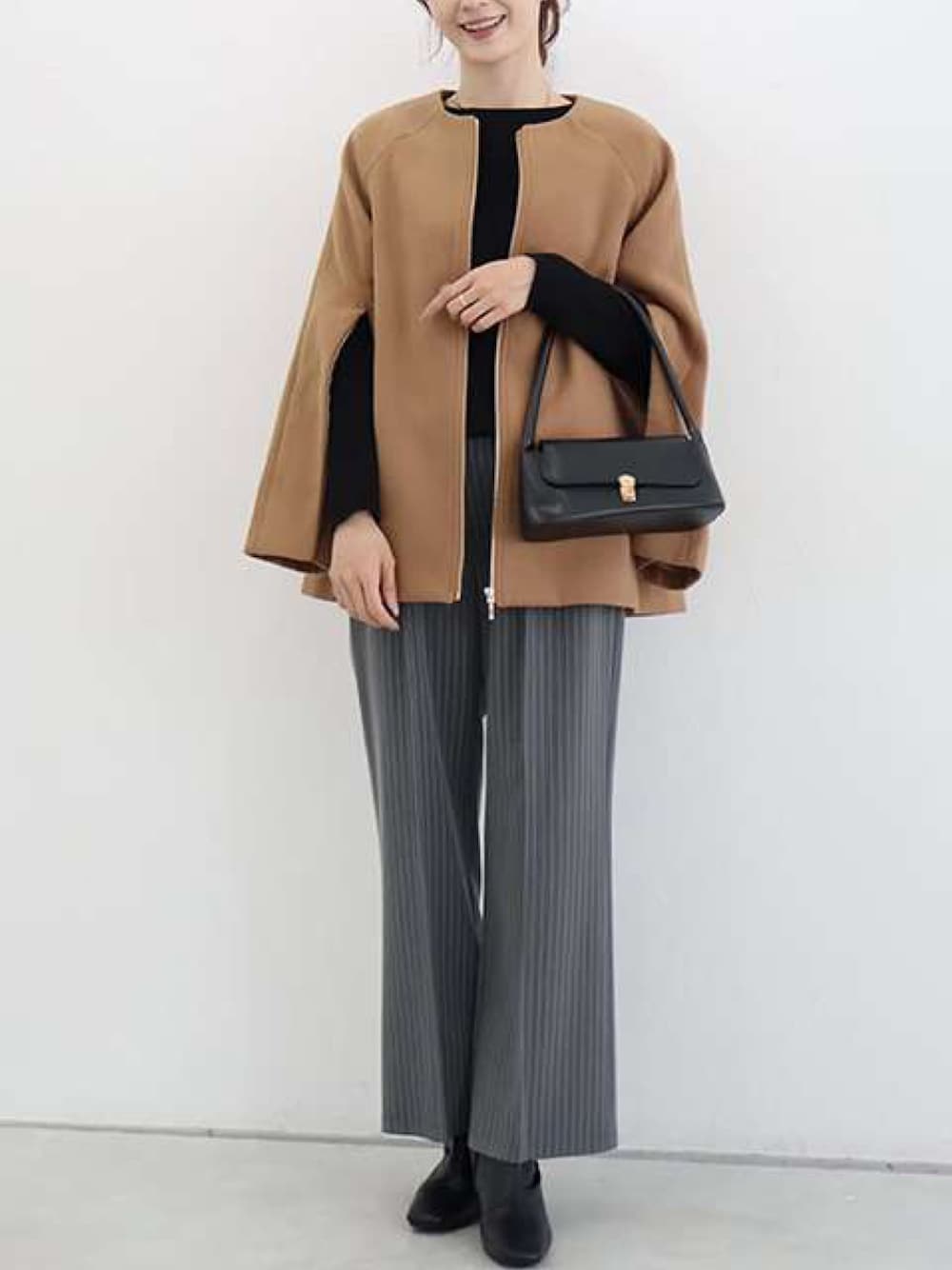 イエロー系のその他アウター、ブラック系のニット/セーター、その他のその他パンツを着用したレディースの秋コーディネートの1枚目の写真