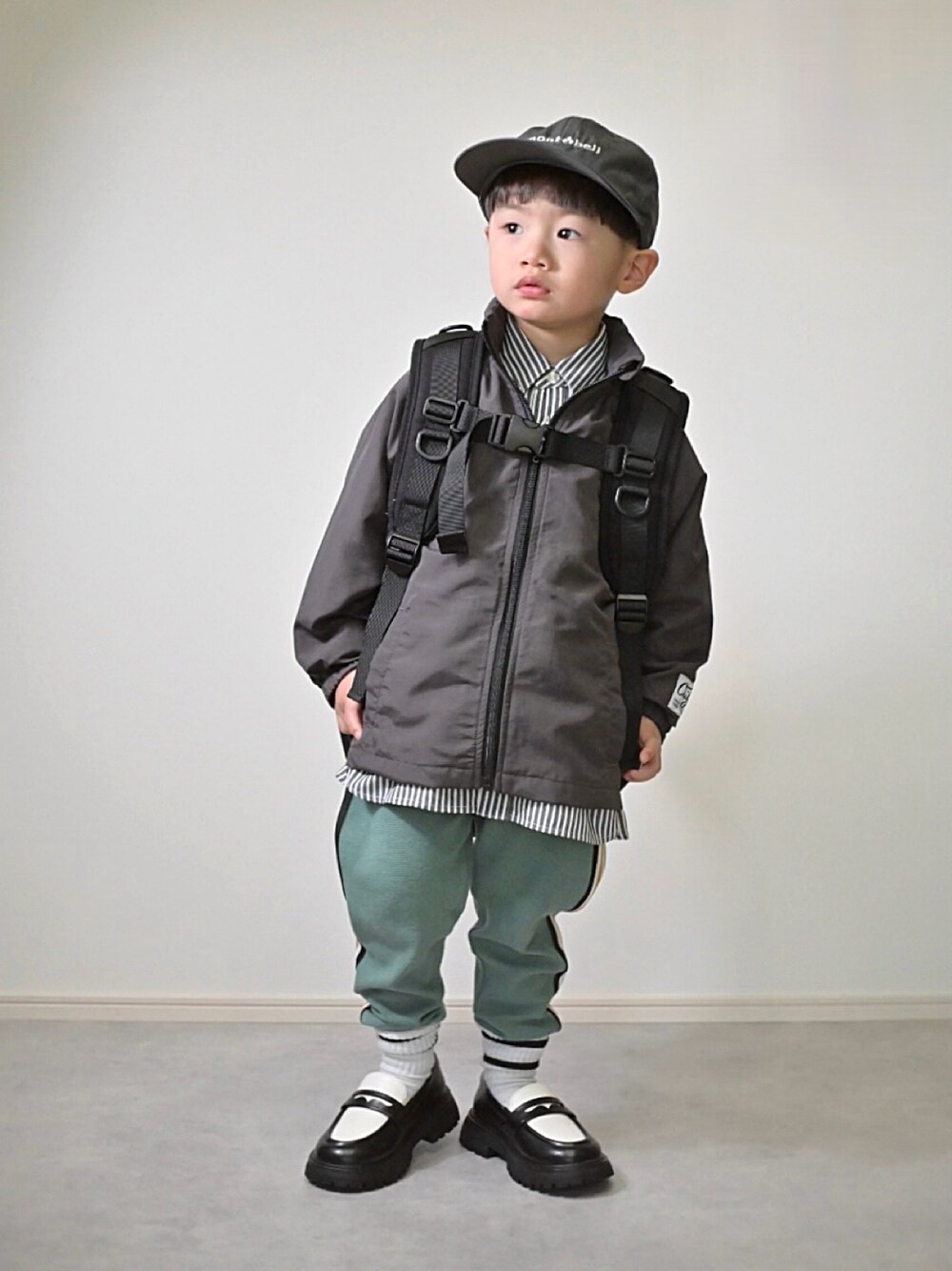 グレー系のブルゾン、グリーン系のその他パンツ、ブラック系のシャツ/ブラウスを着用したキッズの冬コーディネートの1枚目の写真