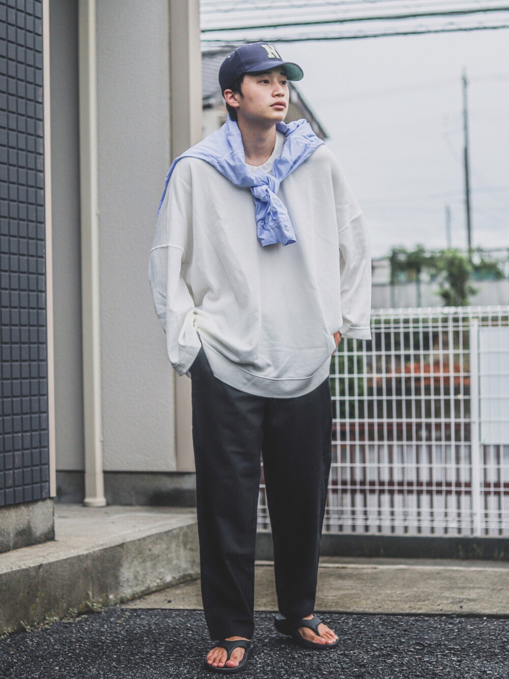 ブラック系のその他パンツ、ブラック系のサンダル、ブルー系のキャップを着用したメンズの夏コーディネートの1枚目の写真