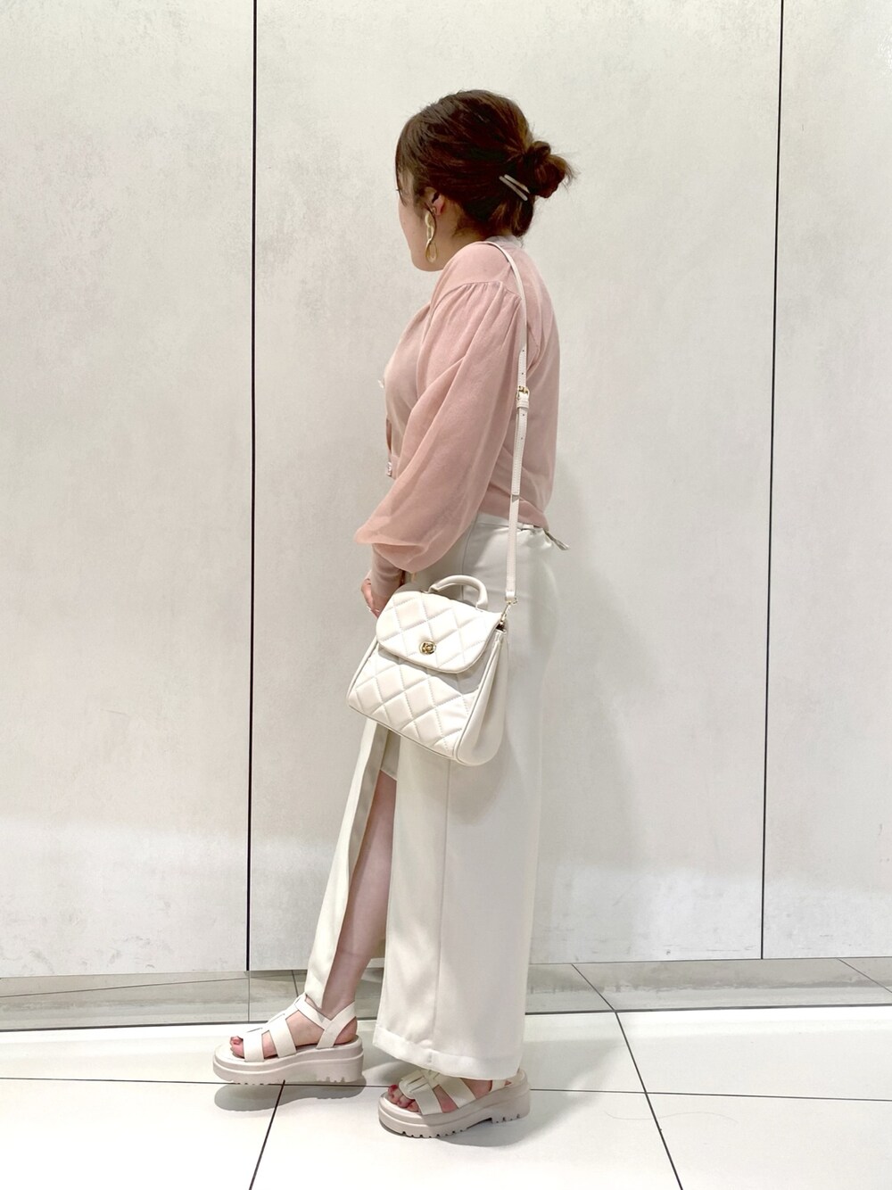 ホワイト系のスカート、ホワイト系のサンダル、ホワイト系のショルダーバッグを着用したレディースの春コーディネートの2枚目の写真