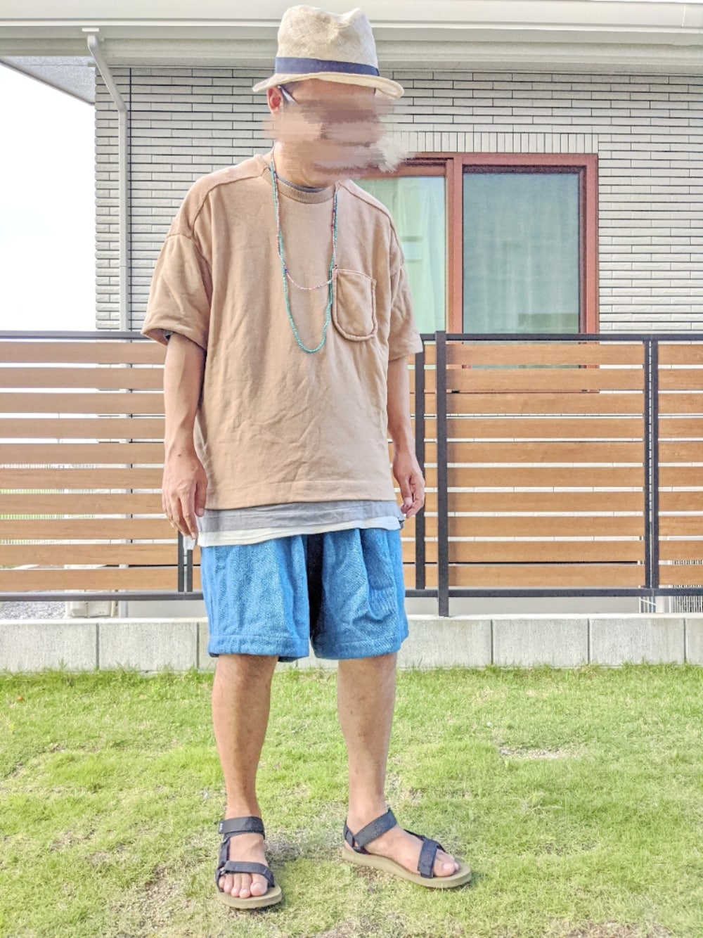 ホワイト系のタンクトップ、ブルー系のデニムパンツ、グリーン系のサンダルを着用したメンズの夏コーディネートの1枚目の写真