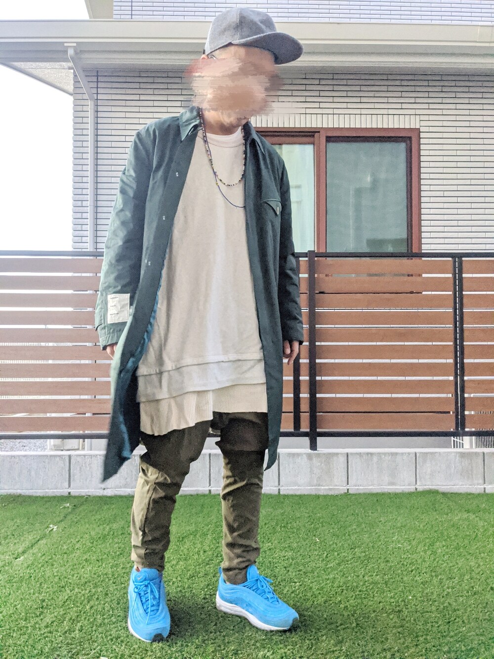 グリーン系のステンカラーコート、ピンク系のスウェット、グリーン系のその他パンツを着用したメンズの冬コーディネートの1枚目の写真