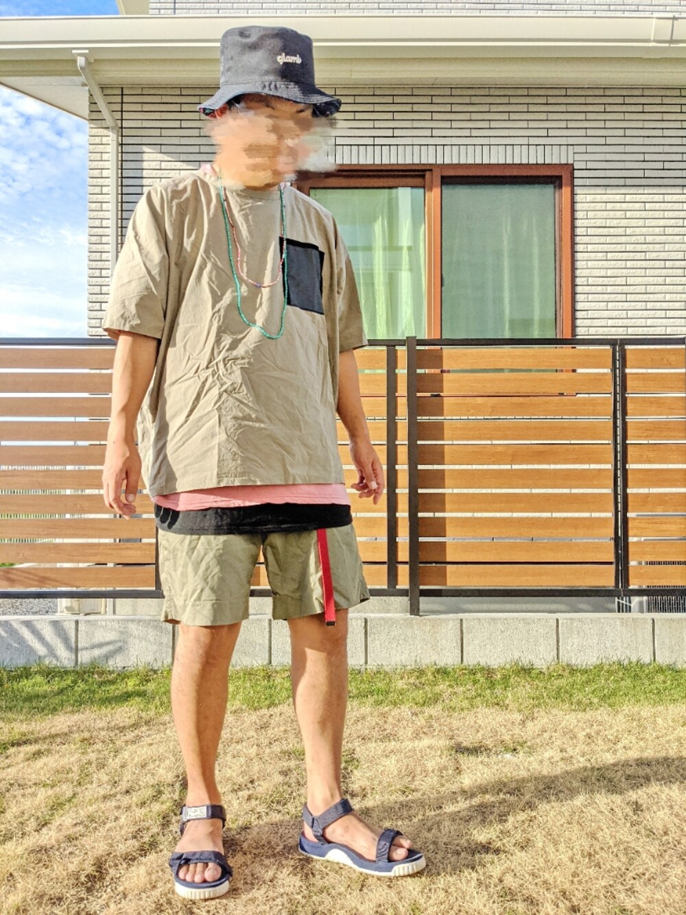 グリーン系のTシャツ/カットソー、ブラック系のタンクトップ、グリーン系のチノパンツを着用したメンズの夏コーディネートの1枚目の写真