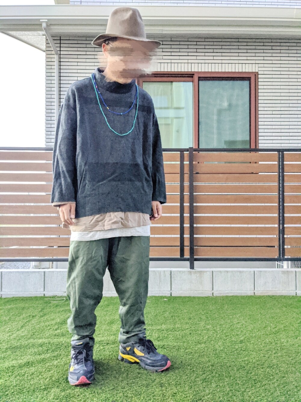 グレー系のニット/セーター、ベージュ系のTシャツ/カットソー、グレー系のタンクトップを着用したメンズの秋コーディネートの1枚目の写真