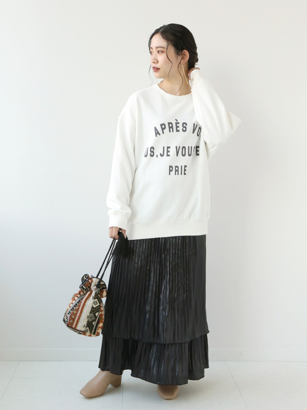 ホワイト系のTシャツ/カットソー、ブラック系のスカート、ベージュ系のバッグを着用したレディースの秋コーディネートの1枚目の写真