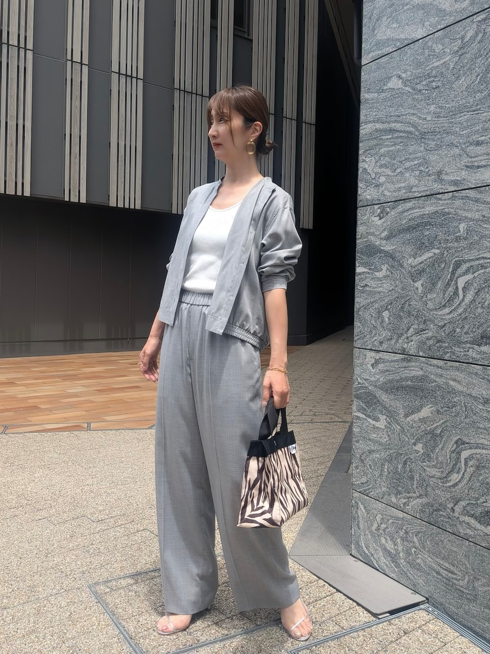 グレー系のその他パンツ、ブラック系のトートバッグを着用したレディースの夏コーディネートの1枚目の写真