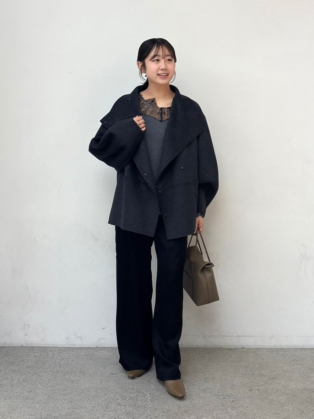 グレー系のその他アウター、ブラック系のカーゴパンツ、グレー系のニット/セーターを着用したレディースの秋コーディネートの1枚目の写真