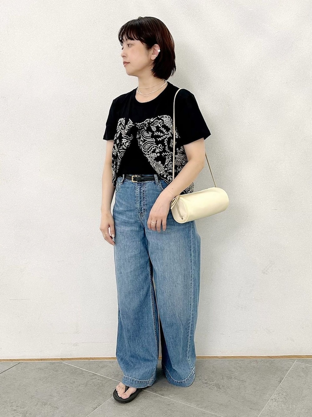 ブルー系のデニムパンツ、ブラック系のTシャツ/カットソー、イエロー系のショルダーバッグを着用したレディースの夏コーディネートの1枚目の写真