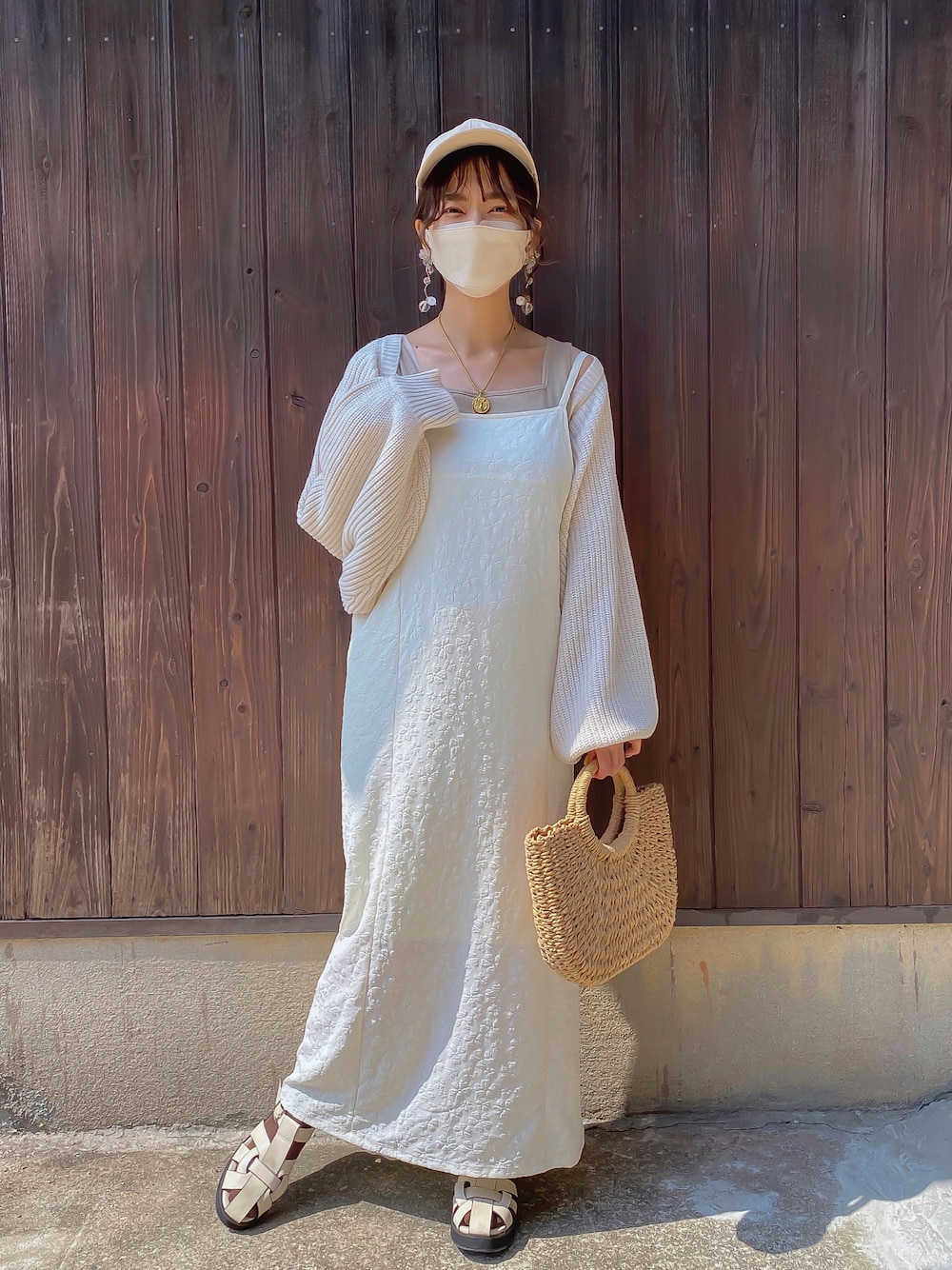 ホワイト系のワンピース、ホワイト系のカーディガン/ボレロ、ベージュ系のタンクトップを着用したレディースの春コーディネートの1枚目の写真