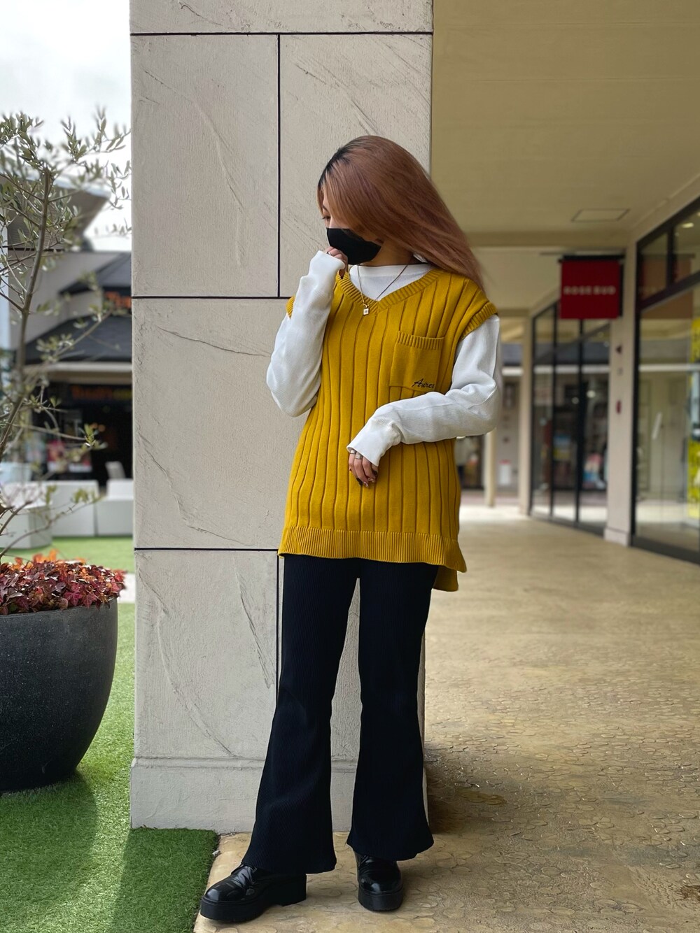 イエロー系のニット/セーター、ホワイト系のTシャツ/カットソーを着用したレディースの冬コーディネートの1枚目の写真