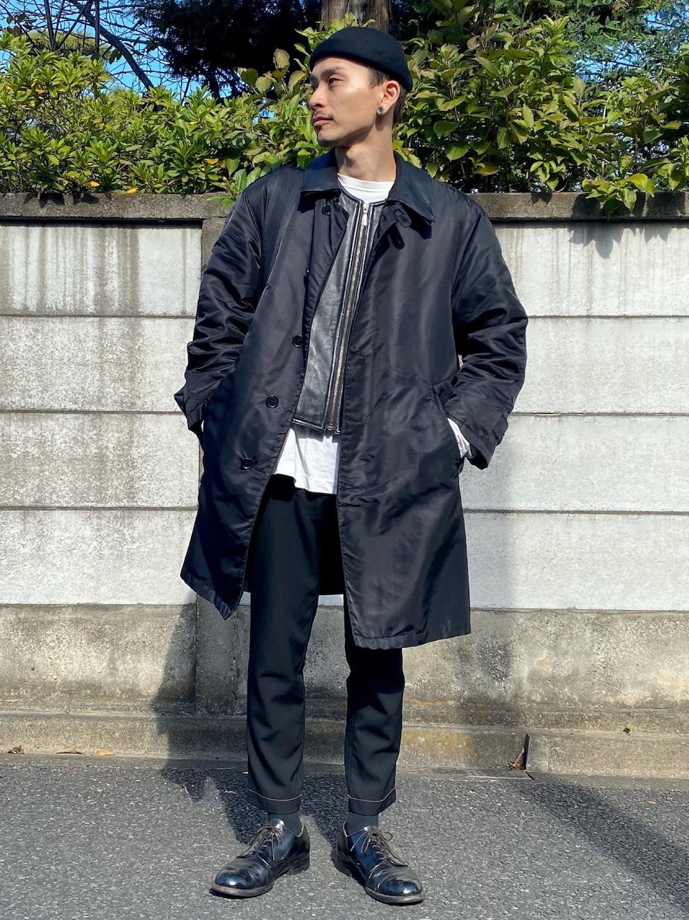 ブラック系のベスト、ホワイト系のTシャツ/カットソー、ブラック系のステンカラーコートを着用したメンズの秋コーディネートの1枚目の写真