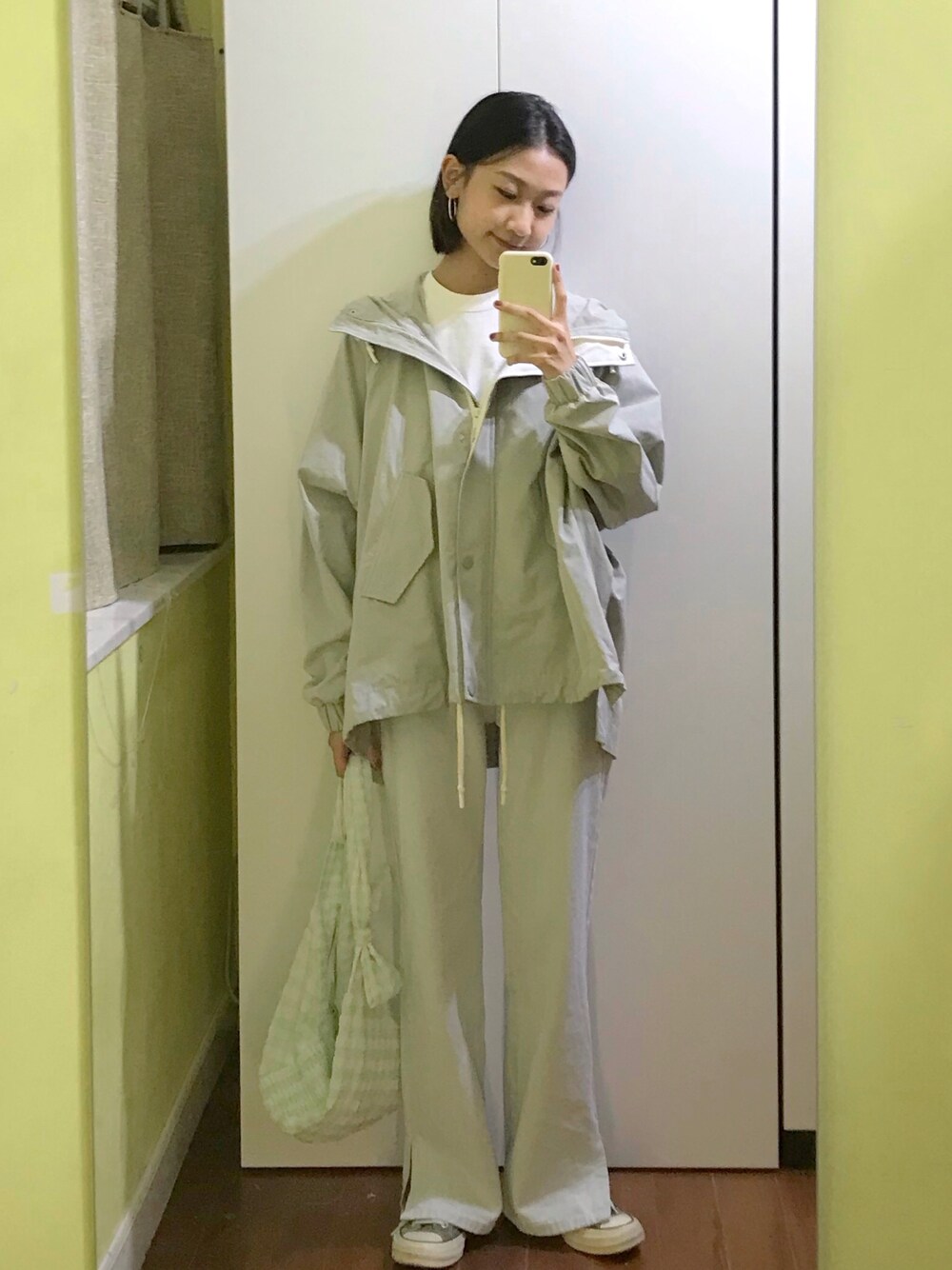 グリーン系のマウンテンパーカー、ホワイト系のTシャツ/カットソー、グリーン系のショルダーバッグを着用したレディースの夏コーディネートの1枚目の写真