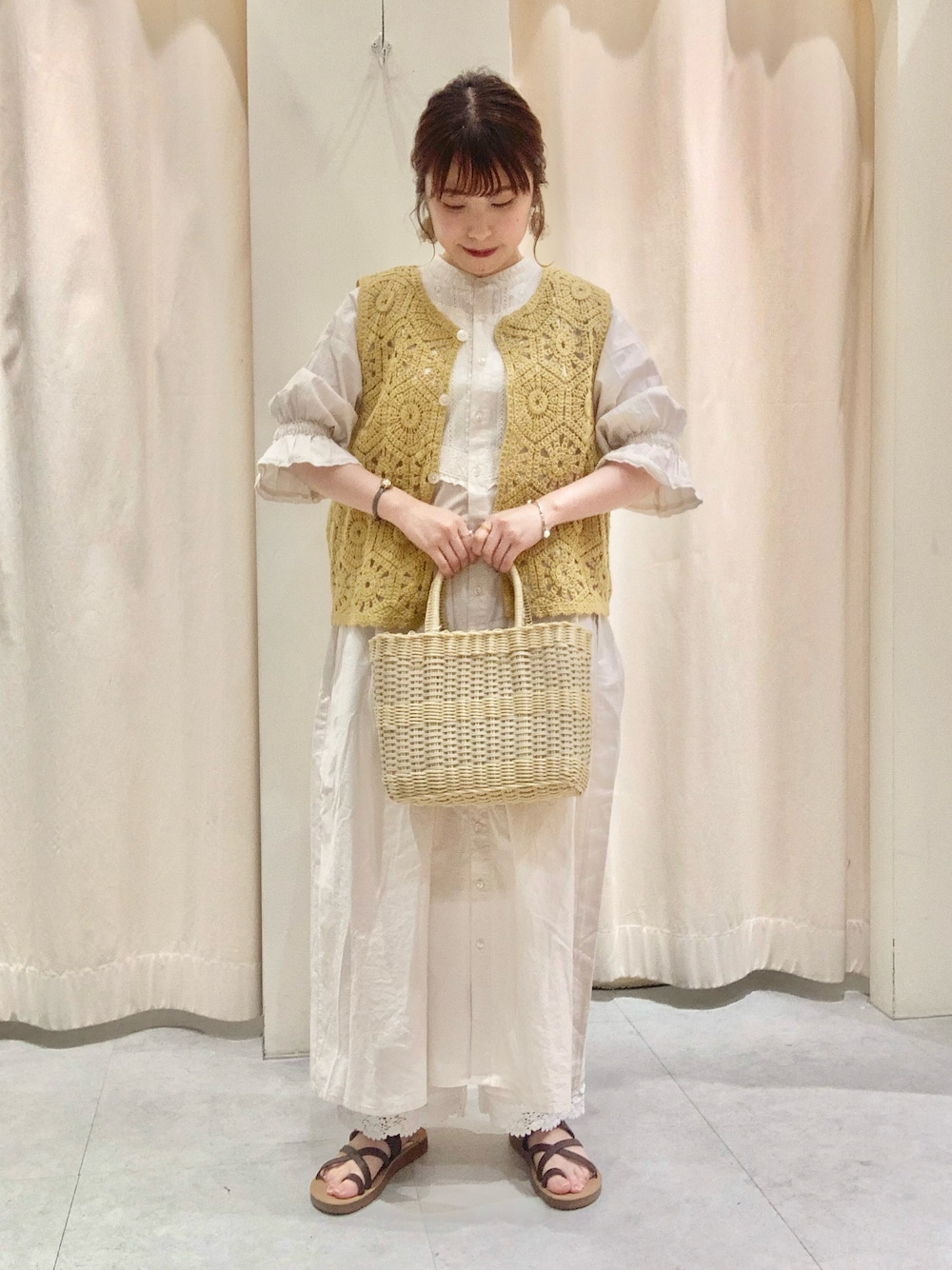 ブラウン系のサンダル、ベージュ系のトートバッグ、イエロー系のニット/セーターを着用したレディースの夏コーディネートの1枚目の写真