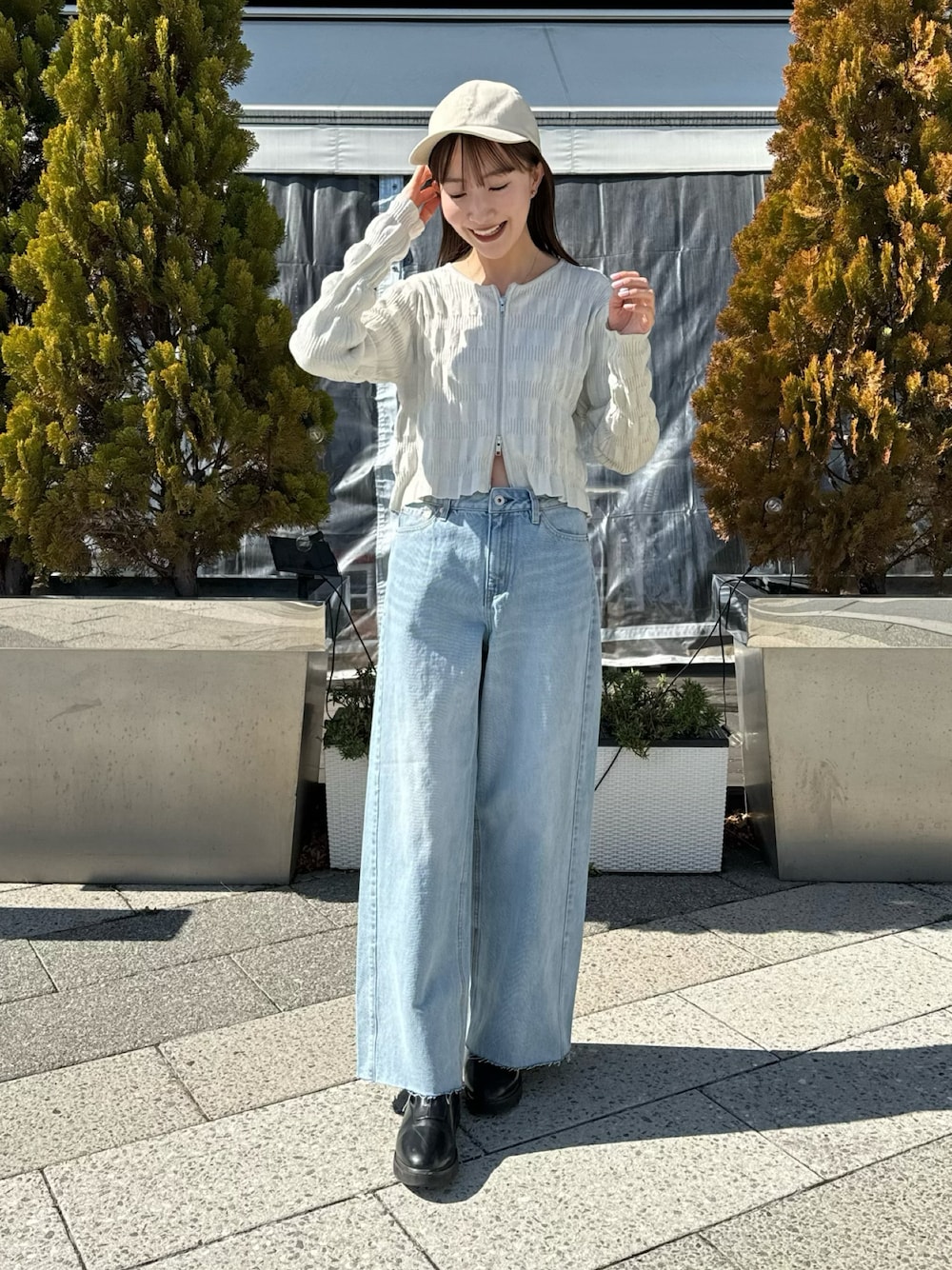 ホワイト系のカーディガン/ボレロ、ブルー系のデニムパンツ、ベージュ系のハットを着用したレディースの春コーディネートの1枚目の写真