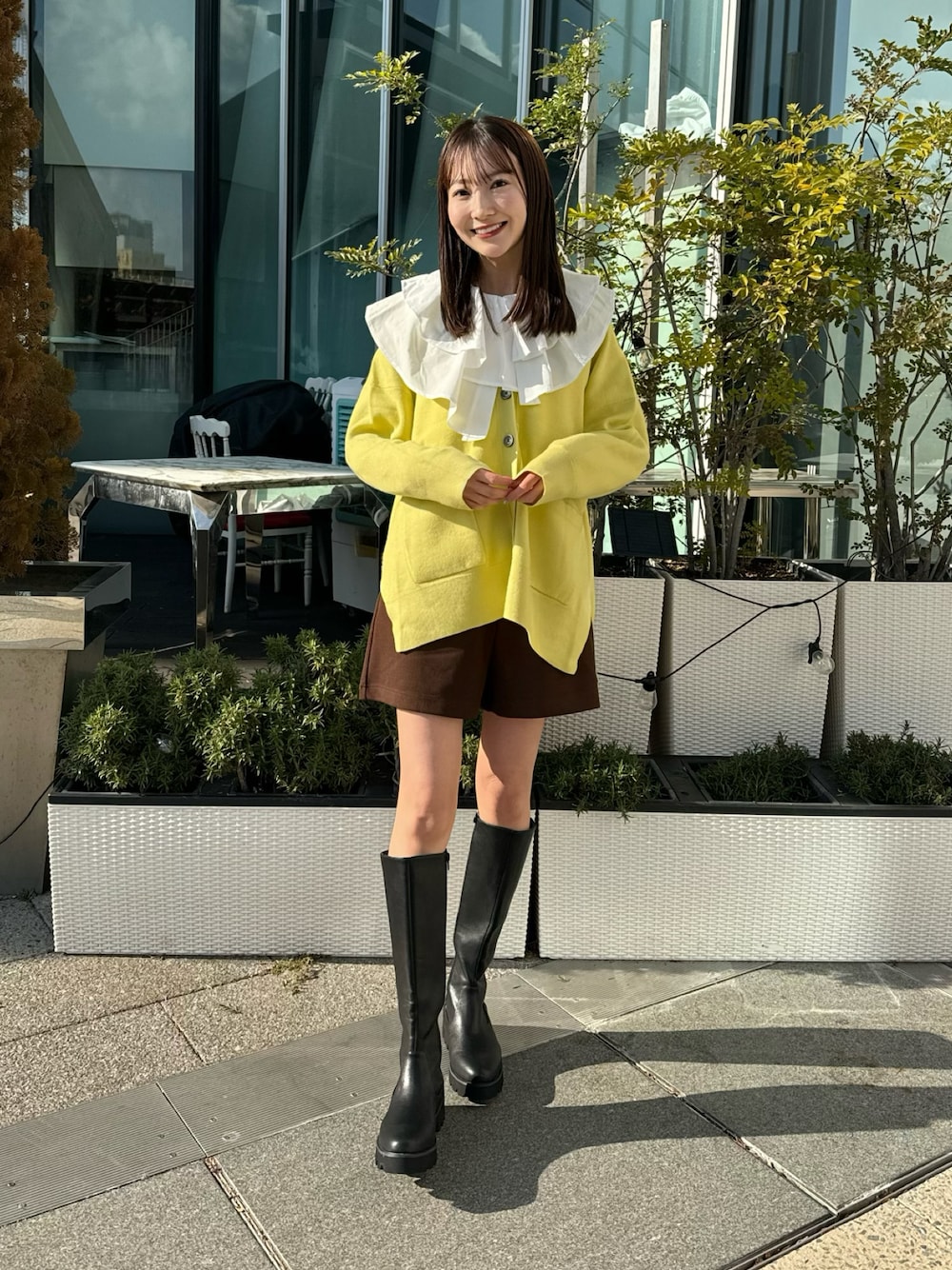 イエロー系のカーディガン/ボレロ、ホワイト系のチュニック、ブラウン系のその他パンツを着用したレディースの冬コーディネートの1枚目の写真