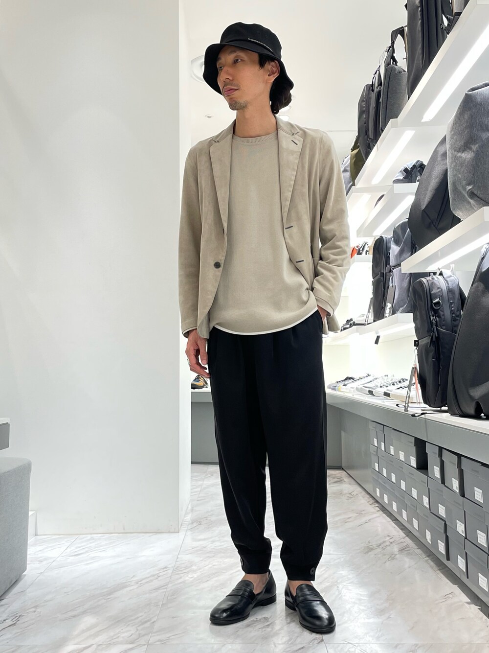 ブラック系のその他パンツ、ブラック系のローファー、ベージュ系のニット/セーターを着用したメンズの秋コーディネートの1枚目の写真