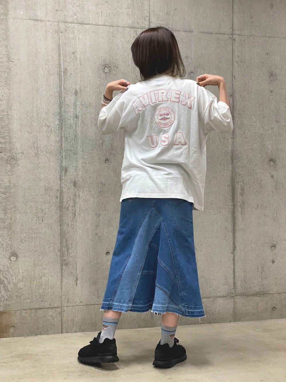 ブルー系のデニムスカート、ホワイト系のTシャツ/カットソー、グレー系のソックス/靴下を着用したレディースの夏コーディネートの1枚目の写真