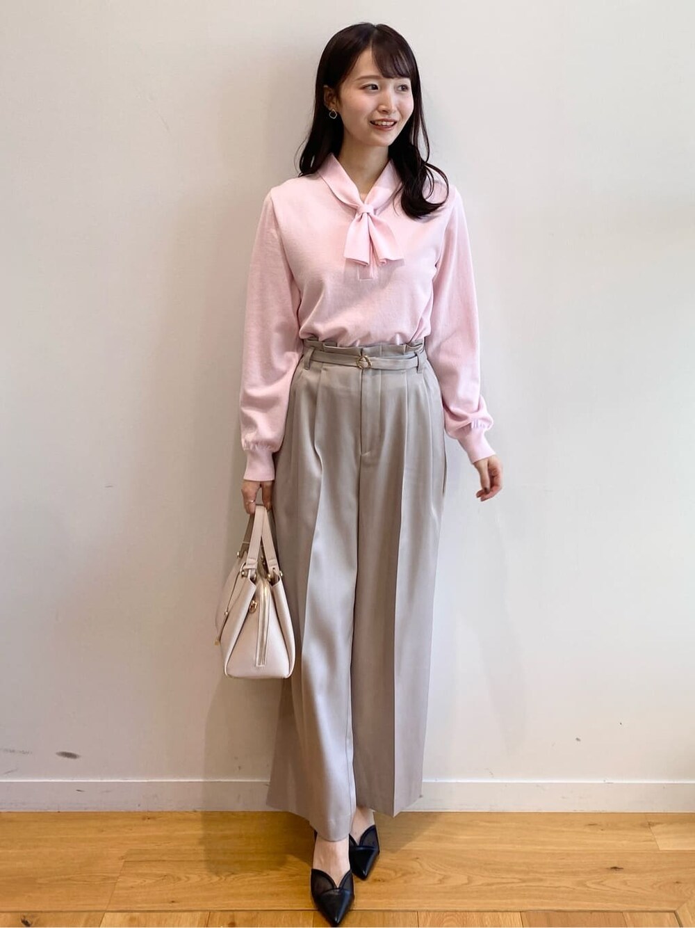 ピンク系のニット/セーター、ベージュ系のその他パンツ、ベージュ系のショルダーバッグを着用したレディースの冬コーディネートの1枚目の写真