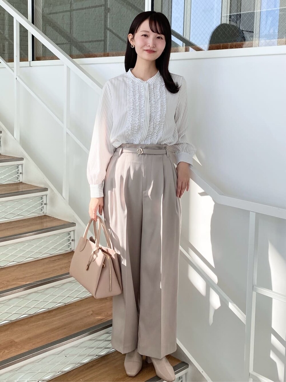 ベージュ系のその他パンツ、ベージュ系のボストンバッグ、ベージュ系のブーツを着用したレディースの冬コーディネートの1枚目の写真