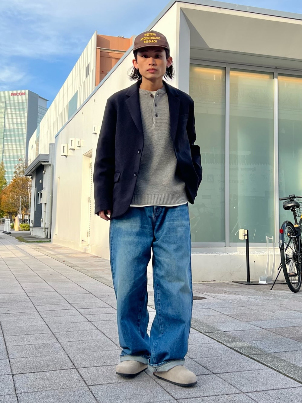 グレー系のニット/セーター、ホワイト系のTシャツ/カットソー、ブラック系のテーラードジャケットを着用したメンズの秋コーディネートの1枚目の写真