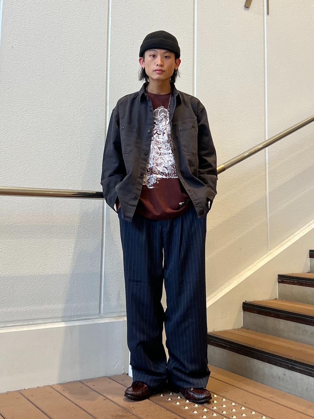 ブルー系のスラックス、ブラック系のシャツ/ブラウス、ブラウン系のTシャツ/カットソーを着用したメンズの秋コーディネートの1枚目の写真