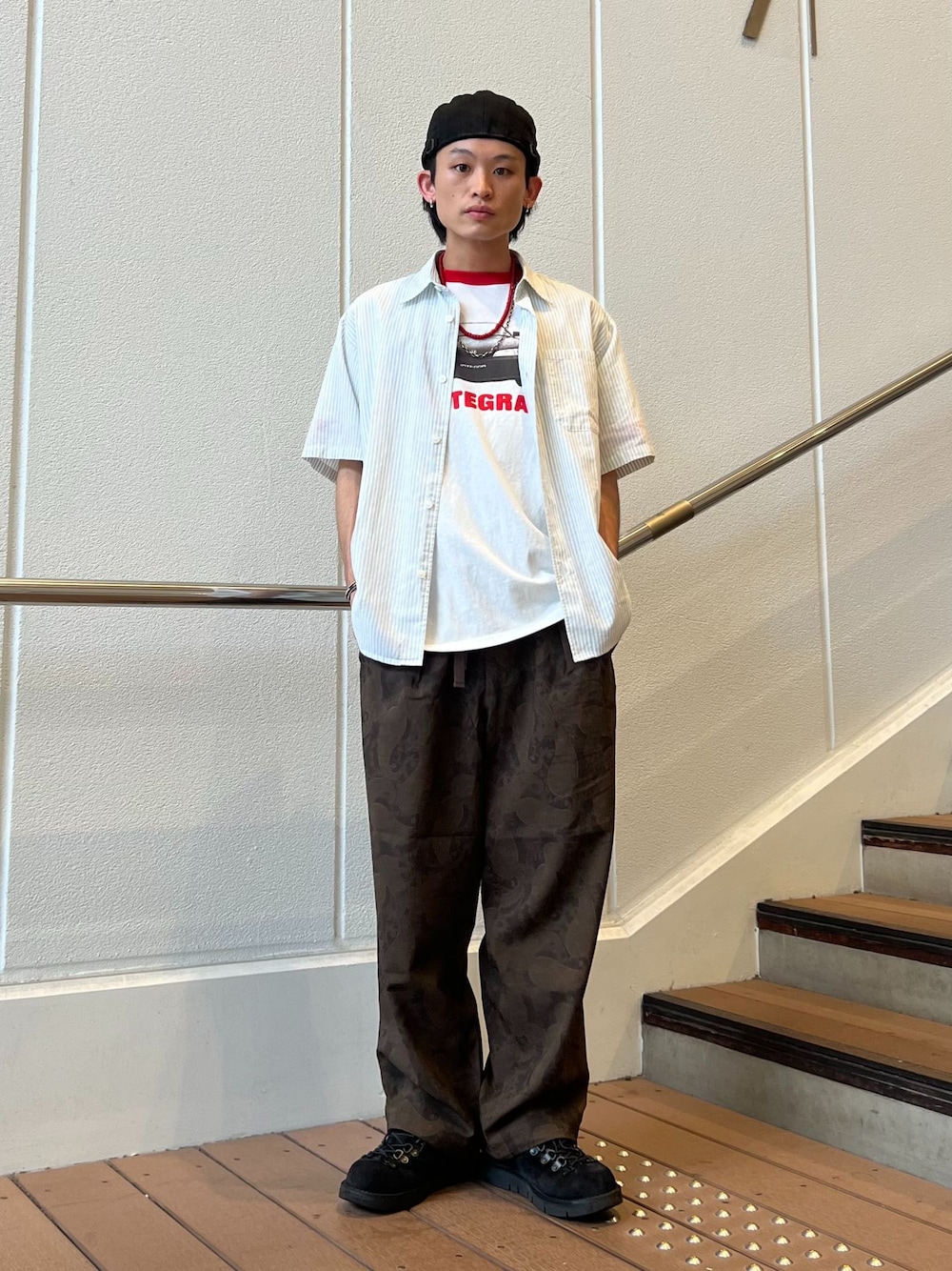 ブラウン系のスラックス、グリーン系のシャツ/ブラウス、ホワイト系のTシャツ/カットソーを着用したメンズの夏コーディネートの1枚目の写真