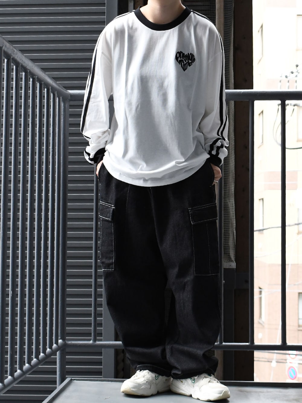 ホワイト系のTシャツ/カットソー、ブラック系のカーゴパンツを着用したメンズの秋コーディネートの1枚目の写真