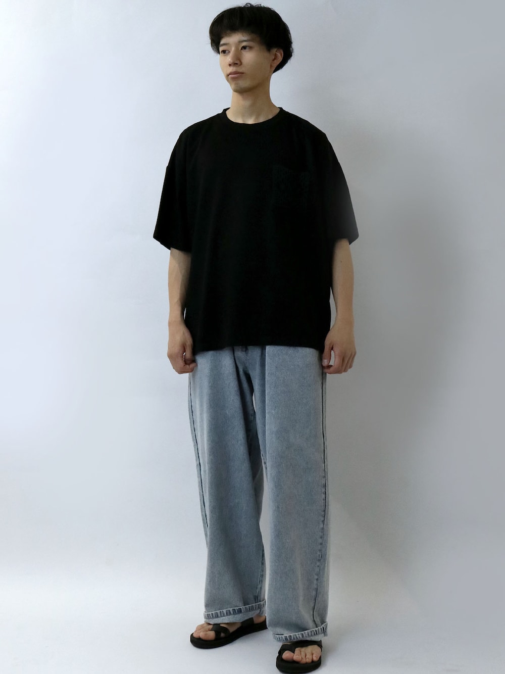 ブラック系のTシャツ/カットソー、ブルー系のデニムパンツ、ブラック系のサンダルを着用したメンズの夏コーディネートの1枚目の写真