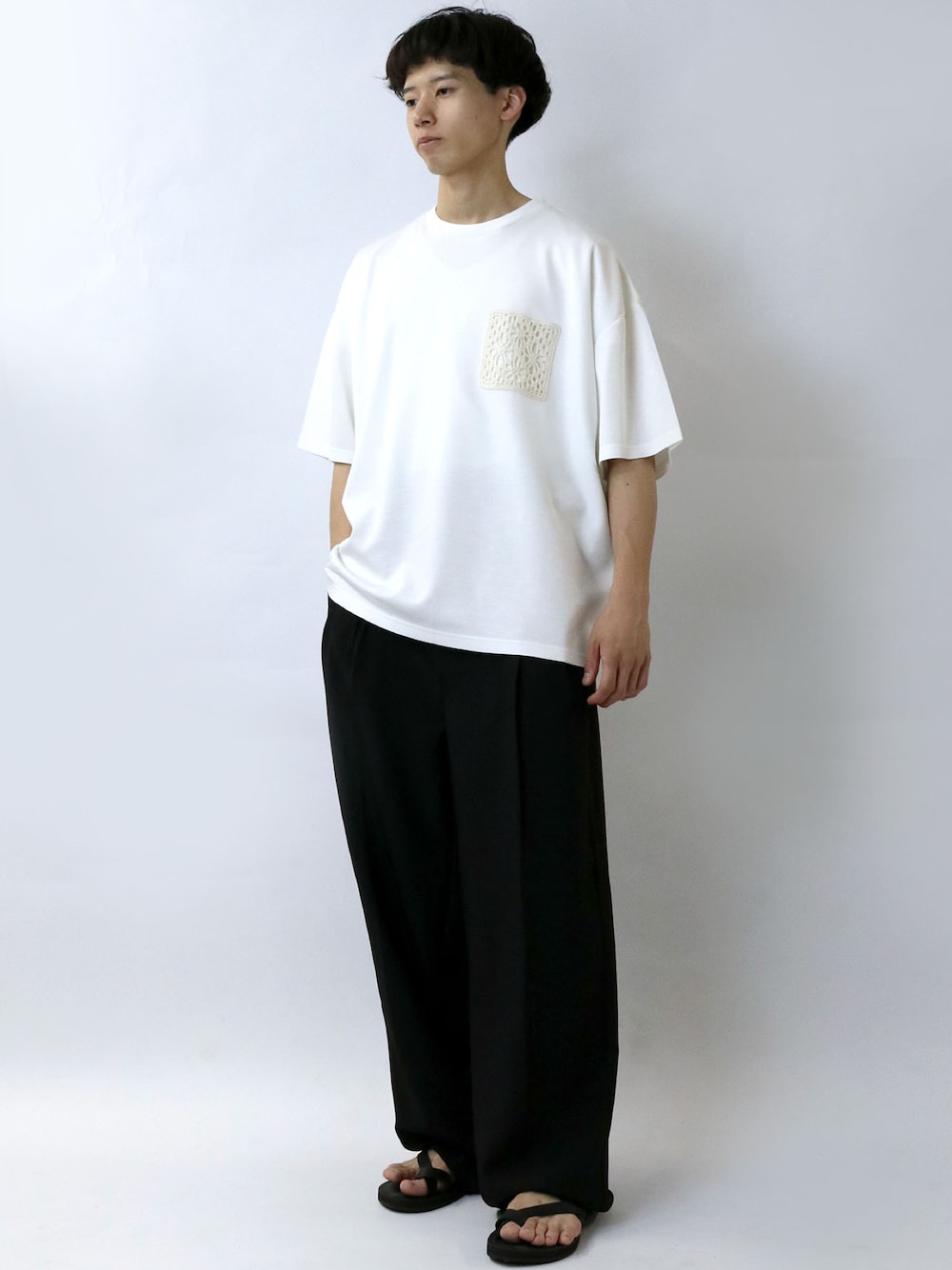 ホワイト系のTシャツ/カットソー、ブラック系のデニムパンツ、ブラック系のサンダルを着用したメンズの夏コーディネートの1枚目の写真