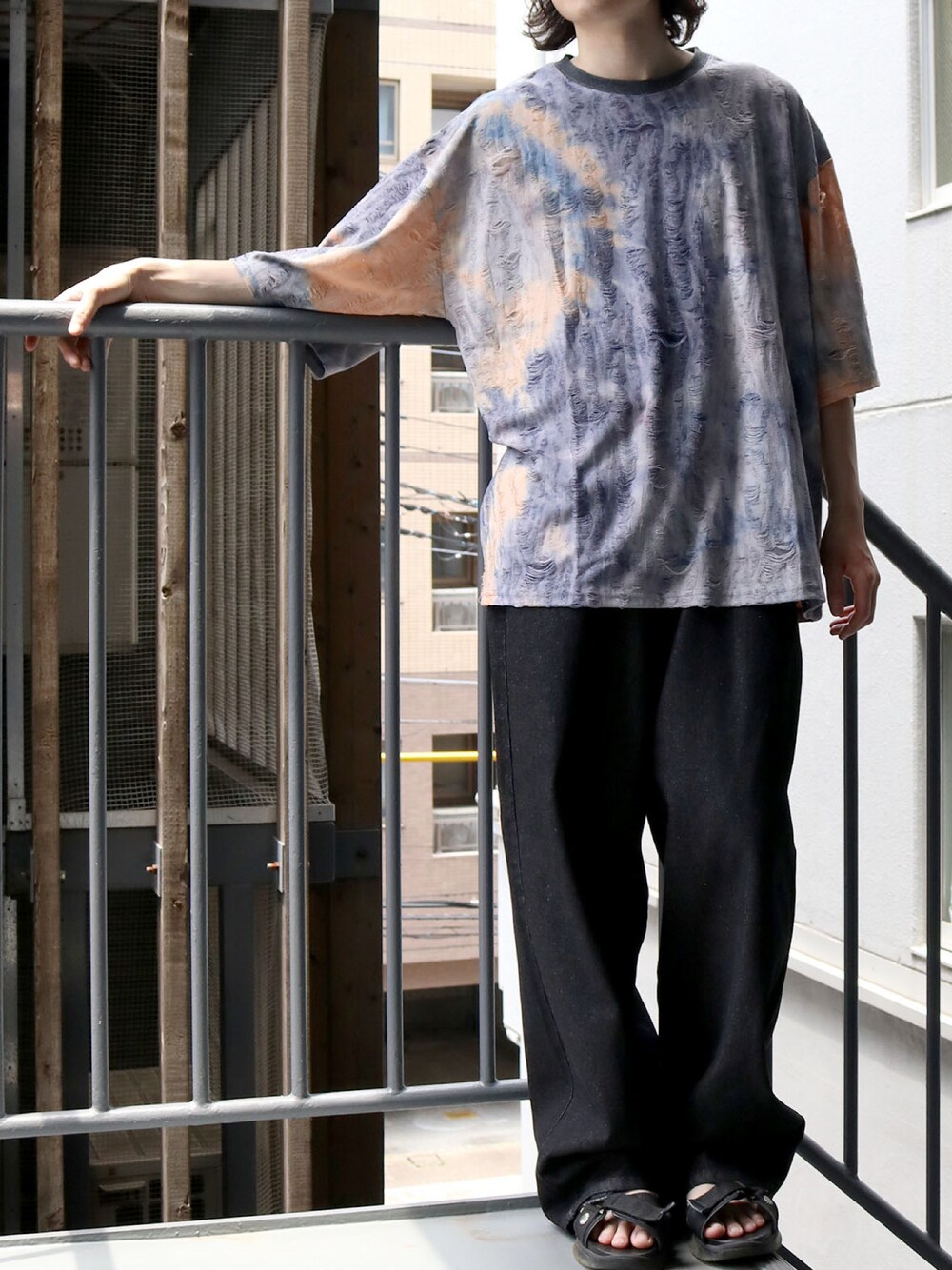 ベージュ系のTシャツ/カットソー、ブラック系のスラックス、ブラック系のサンダルを着用したメンズの夏コーディネートの1枚目の写真