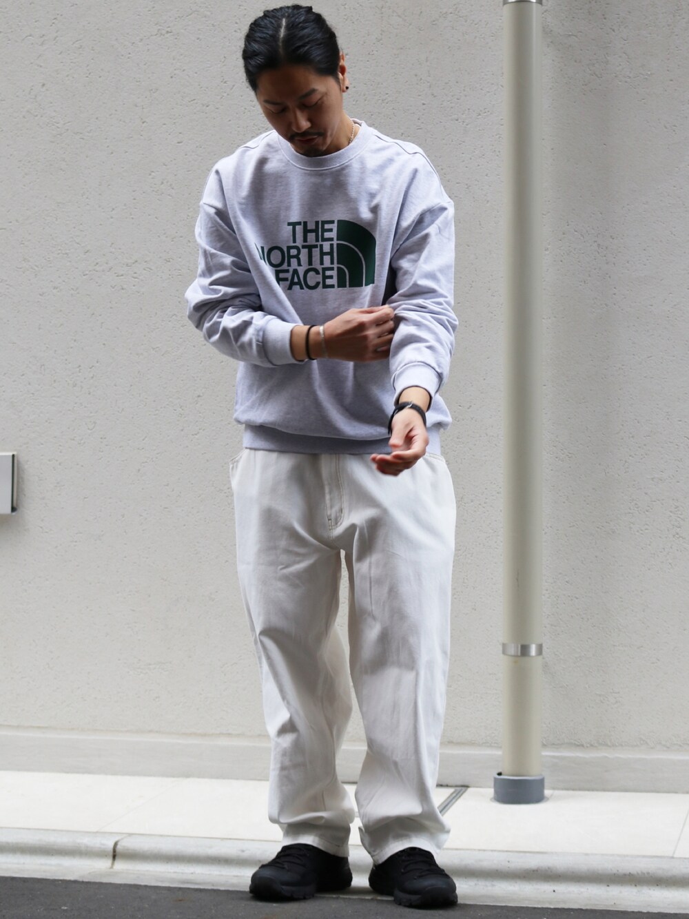 グレー系のスウェット、ホワイト系のデニムパンツを着用したメンズの冬コーディネートの1枚目の写真