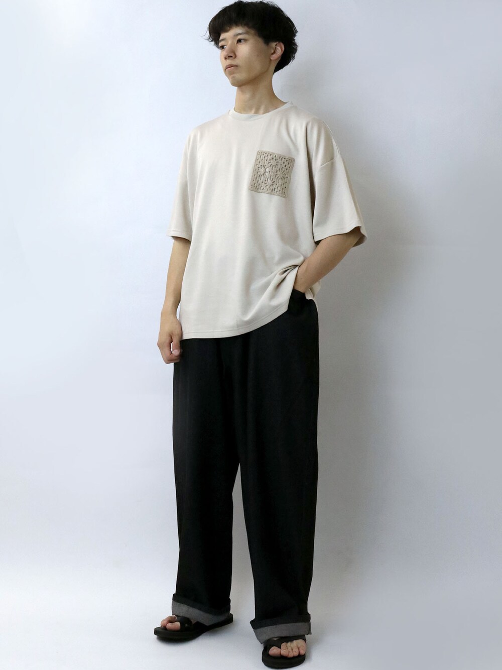 ベージュ系のTシャツ/カットソー、ブラック系のスラックス、ブラック系のサンダルを着用したメンズの夏コーディネートの1枚目の写真