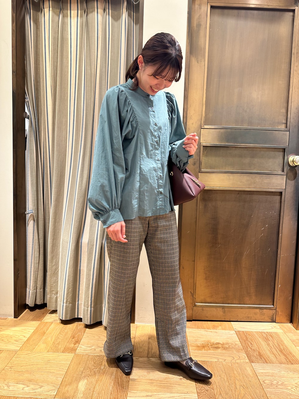 グリーン系のシャツ/ブラウス、レッド系のハンドバッグ、ブラウン系のその他パンツを着用したレディースの秋コーディネートの1枚目の写真