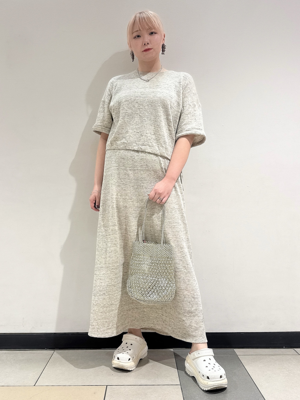 グレー系のTシャツ/カットソー、グレー系のスカート、シルバー系のトートバッグを着用したレディースの春コーディネートの1枚目の写真