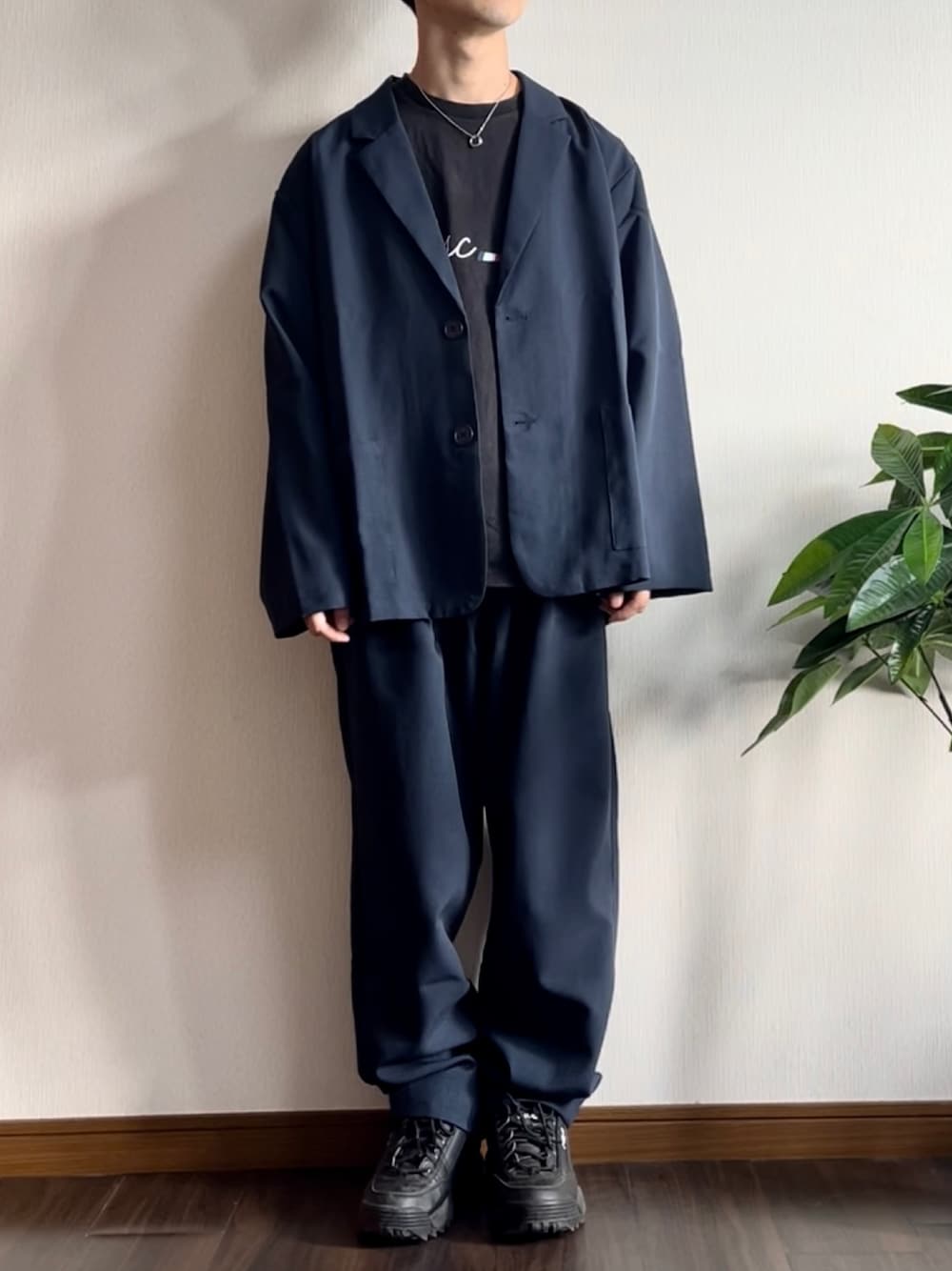 ブルー系のテーラードジャケット、ブラック系のTシャツ/カットソー、ブラック系のスニーカーを着用したメンズの秋コーディネートの1枚目の写真