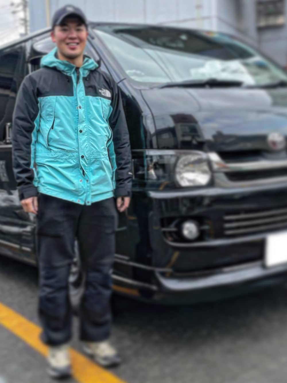 ブラック系のその他パンツ、ベージュ系のスニーカー、ブルー系のマウンテンパーカーを着用したメンズの春コーディネートの1枚目の写真