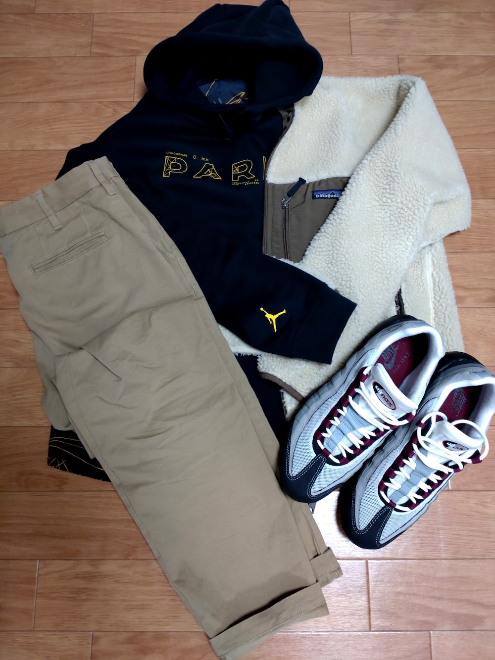 ブラック系のパーカー、グレー系のスニーカー、ベージュ系のブルゾンを着用したメンズの冬コーディネートの1枚目の写真